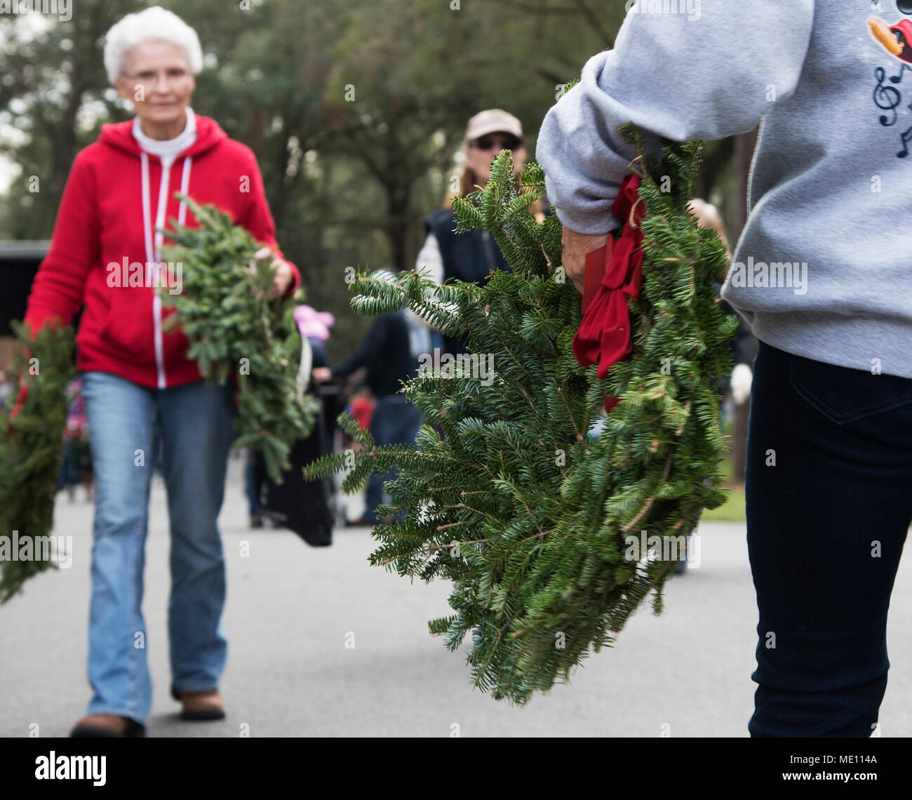 Volunteers walk to various gravesites to place wreaths during the