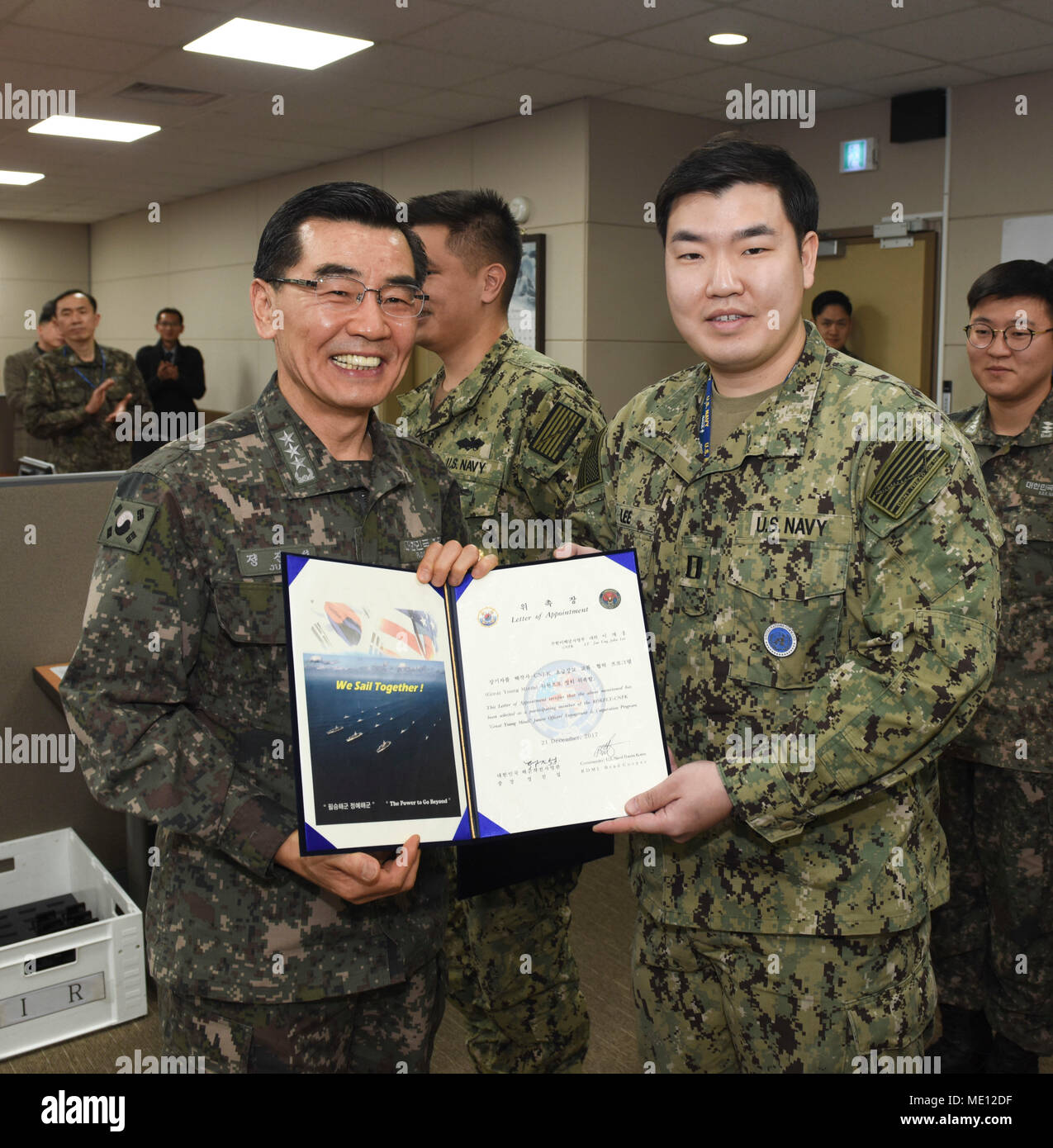 171221-N-TB148-012 BUSAN, Republic of Korea (Dec. 21, 2017) Republic of Korea (ROK) Navy Vice Adm. Jung, Jin-Sup, commander, ROK Fleet, presents Lt. John Lee with a letter of appointment for his selection to the 'Great Young Minds' Junior Officers' Engagement and Cooperation Program. The 'Great Young Minds' initiative brings together hand-selected, young officers from the ROK and U.S. navies and challenges them to develop innovative solutions to further enhance the ROK -U.S. alliance of the future. (U.S. Navy photo by Mass Communication Specialist Seaman William Carlisle) Stock Photo