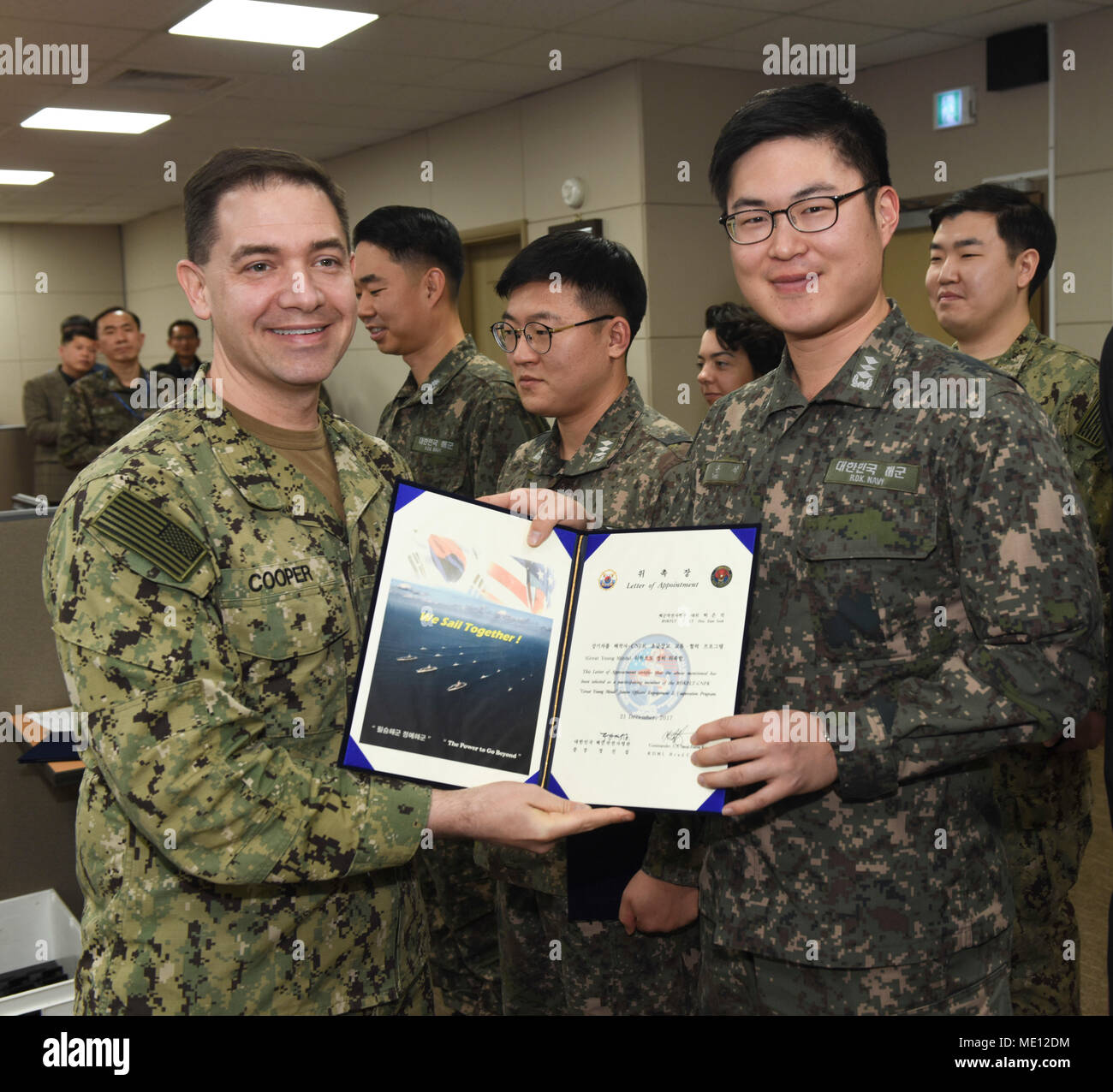 171221-N-TB148-040 BUSAN, Republic of Korea (Dec. 21, 2017) Rear Adm. Brad Cooper, commander, U.S. Naval Forces Korea (CNFK), presents Lt. Han with a letter of appointment for his selection to the 'Great Young Minds' Junior Officers' Engagement and Cooperation Program. The 'Great Young Minds' initiative brings together hand-selected, young officers from the ROK and U.S. navies and challenges them to develop innovative solutions to further enhance the ROK -U.S. alliance of the future. (U.S. Navy photo by Mass Communication Specialist Seaman William Carlisle) Stock Photo