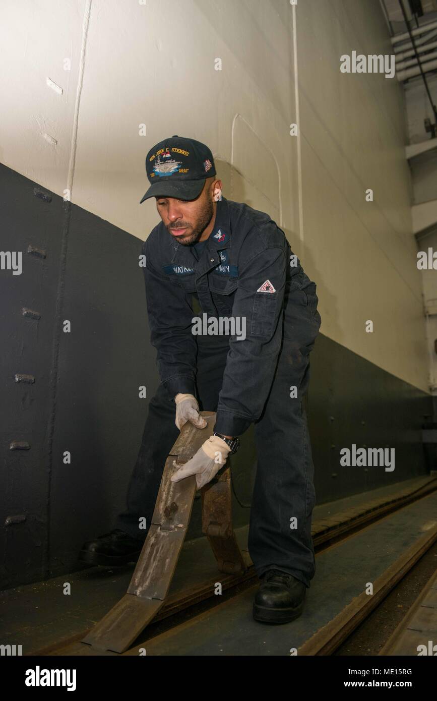 171221-N-EC099-047 – BREMERTON, Wash. (Dec. 21, 2017) Machinist’s Mate 2nd Class Titus Watkins, from Macon, Georgia, lays down a hangar bay door track aboard USS John C. Stennis (CVN 74). John C. Stennis is in port conducting routine training as it continues preparing for its next scheduled deployment. (U.S. Navy photo by Mass Communication Specialist 3rd Class Charles D. Gaddis IV/Released) Stock Photo