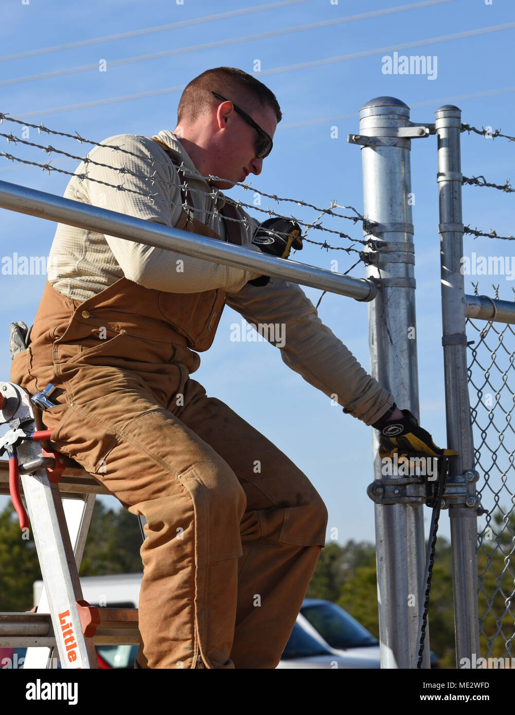 A U.S. Airman assigned to the 20th Civil Engineer Squadron constructs a fence for a new MQ-9 site at Shaw Air Force Base, S.C., Dec. 12, 2018. Airmen began construction following results from an environmental assessment, using available equipment to prevent additional costs to the government and to reduce time waiting for new equipment to be delivered. (U.S. Air Force photo by Airman 1st Class Kathryn R.C. Reaves) Stock Photo