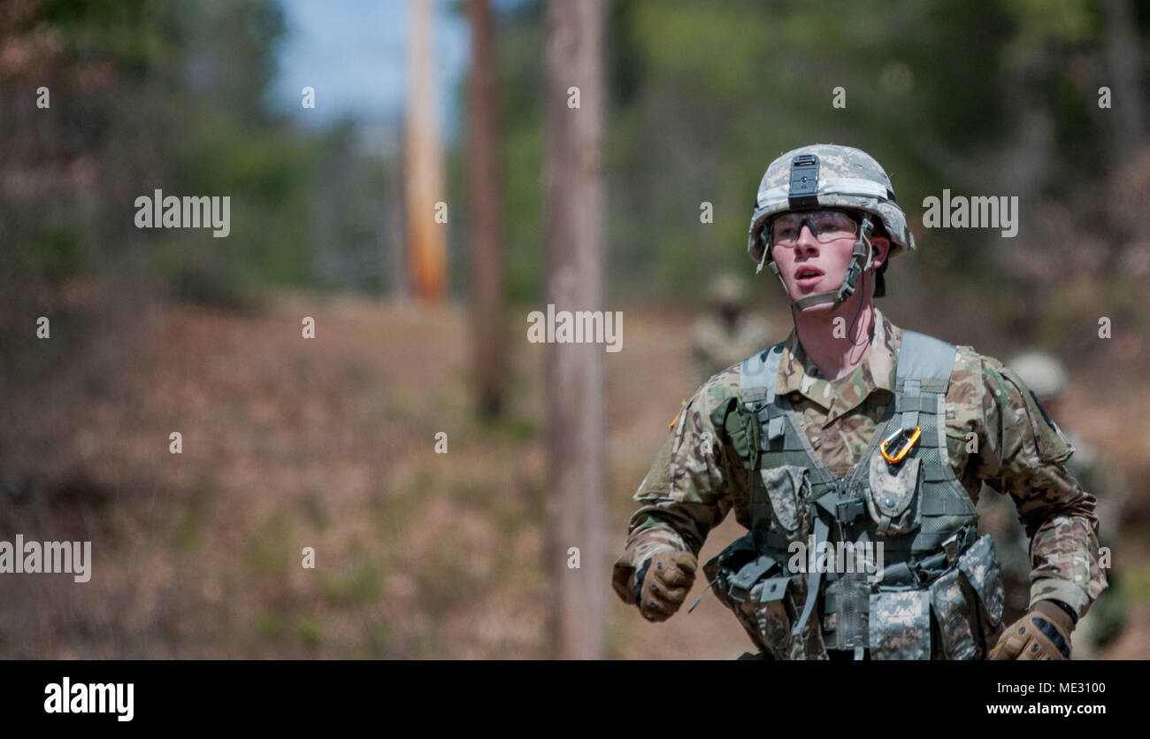 Specialist Benjamin Retz, of the 389th Engineer Battalion, 416th Theatre Engineer Command, races to his next task at a Major Command-level Best Warrior Competition, at Devens Reserve Forces Training Area in Massachusetts, April 18, 2018. Retz headed to an M9 pistol shooting activity after finishing his run through the woods. (U.S. Army Reserve photo by PV2 Hunter E. Eastman) (Photo cropped and edited for effect.) Stock Photo