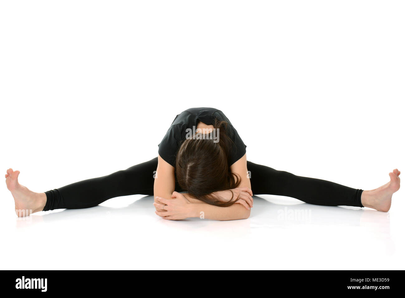 young woman doing yoga asana Upavistha Konasana – Wide Angle Seated Forward Bend Stock Photo