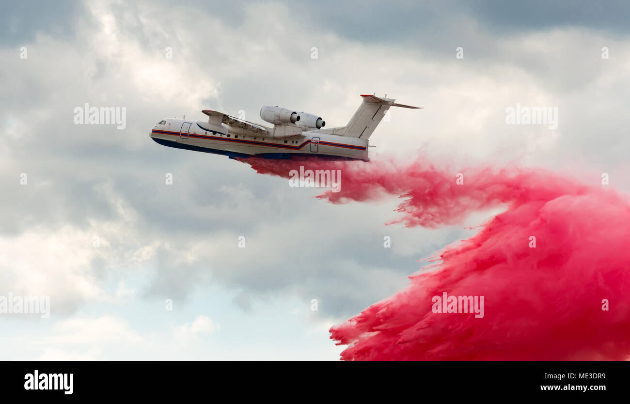 Flying aerial firefighting pour water over the fire Stock Photo