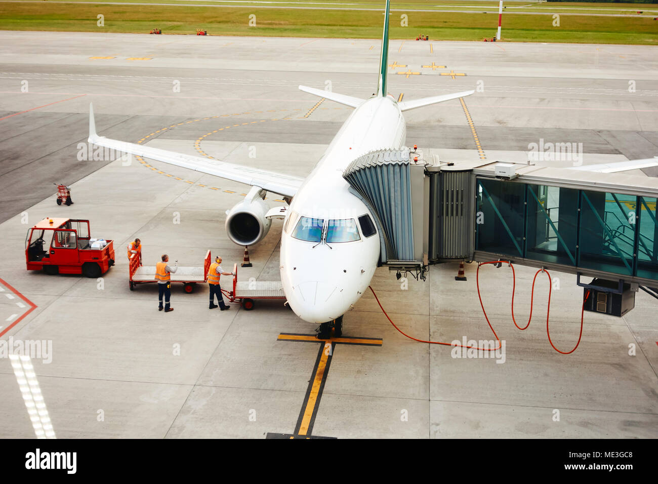 A passenger jet airplane docked at an airport stand. Stock Photo