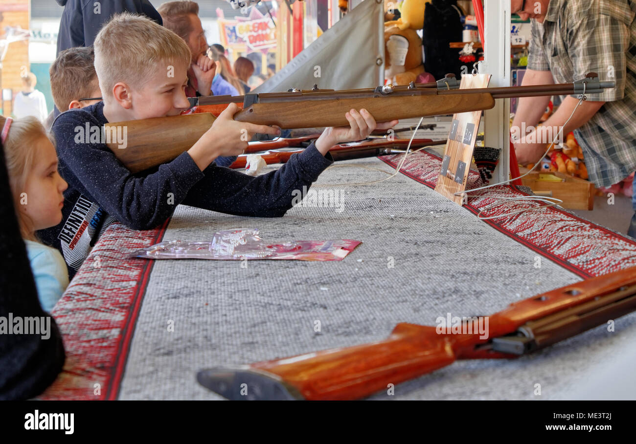 Brunswick, Lower Saxony, April 15, 2018: Boy with a loaded rifle at a shooting range, fairground Stock Photo