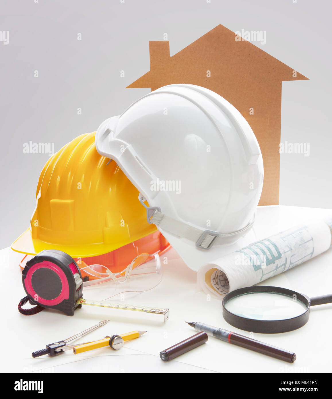 engineering working table writing tool ,equipment ,and safety helmet against two point perspective of building exterior Stock Photo