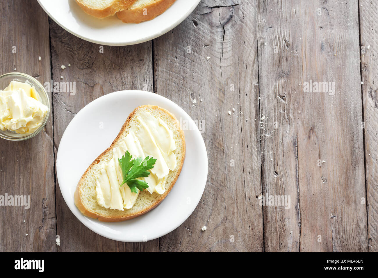 Butter and bread for breakfast on rustic wooden background with copy space. Morning breakfast, butter and toasts. Stock Photo