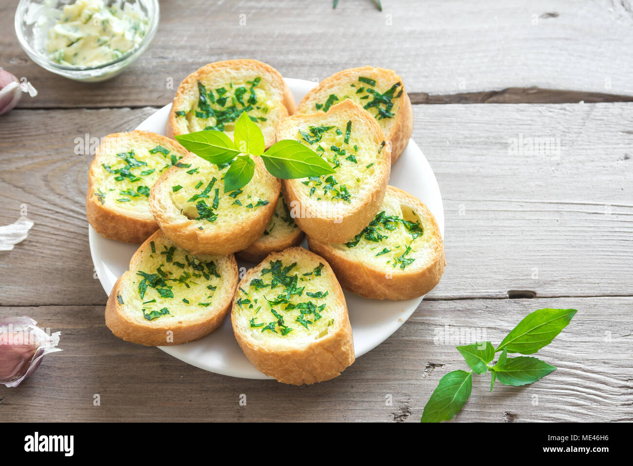 Toasted bread with garlic and herbs with ingredients over wooden