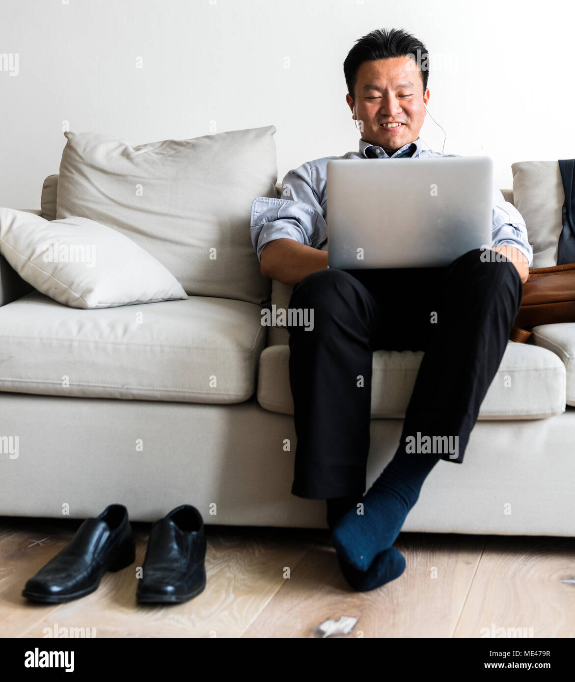 Asian businessman taking break laying on couch Stock Photo Alamy
