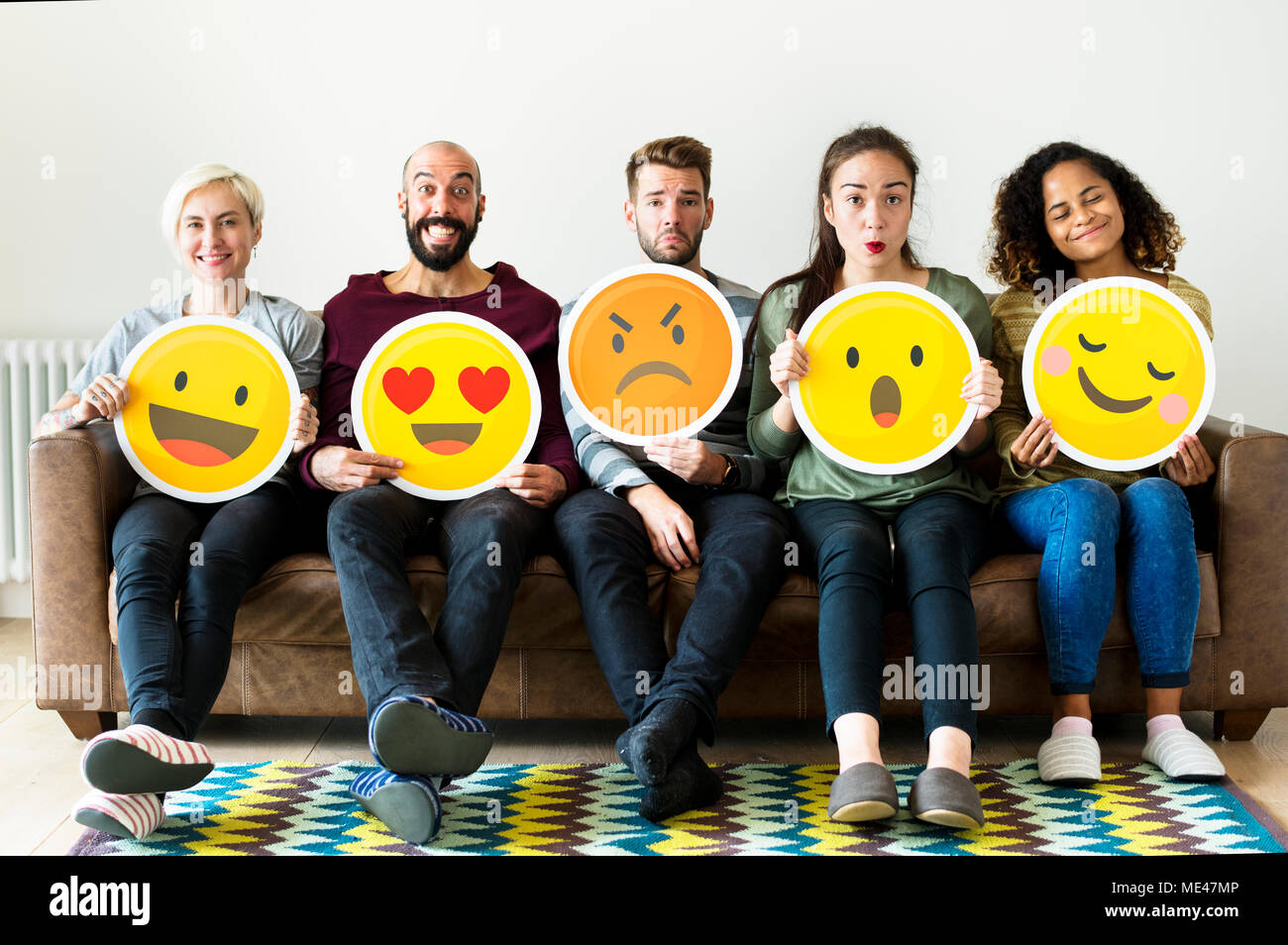 Group of diverse people holding emoticon icons Stock Photo - Alamy