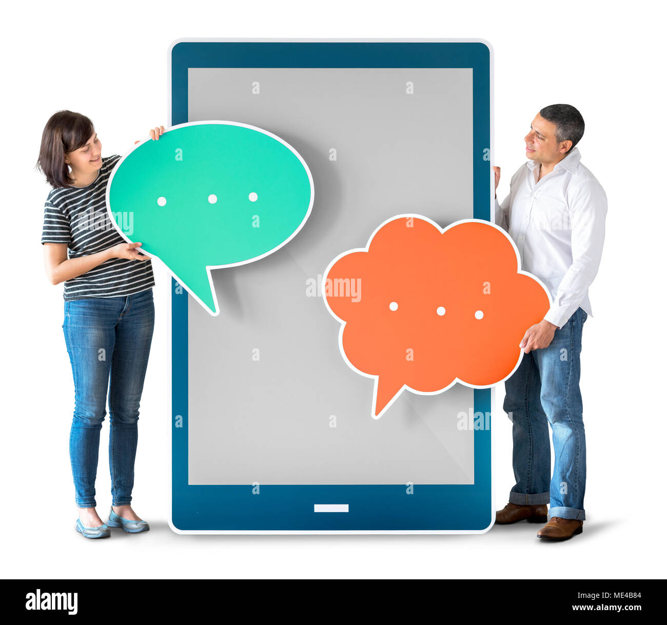 Diverse people holding speech bubbles and tablet Stock Photo
