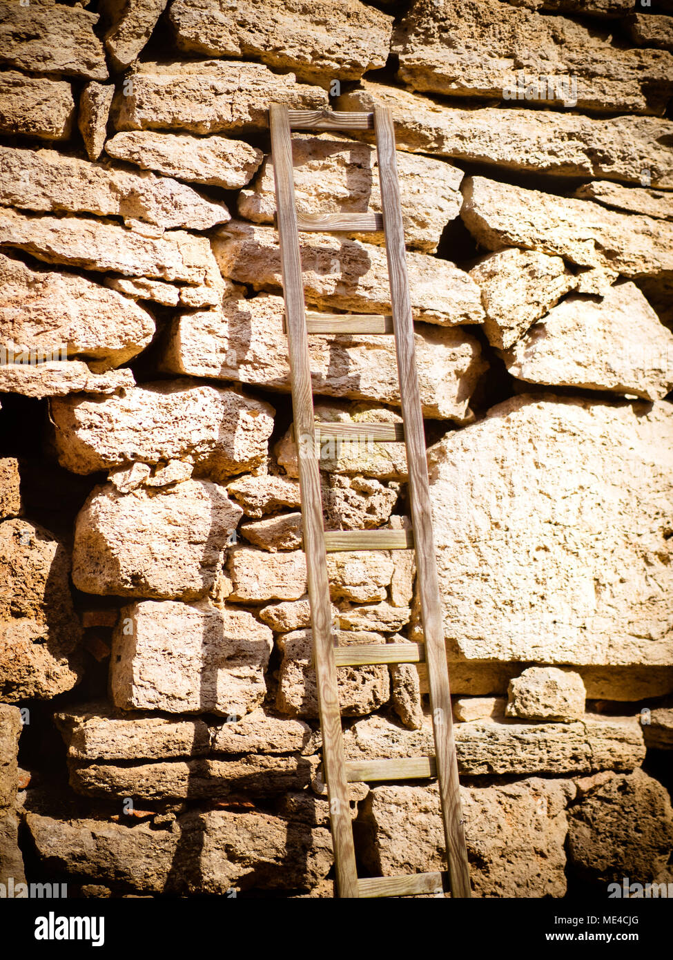 The wooden ladder on the stone wall Stock Photo
