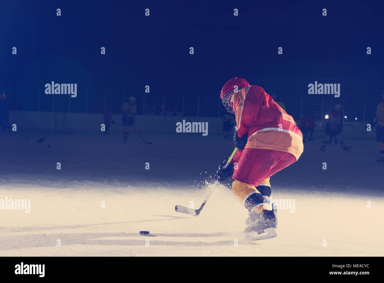 teen girl children ice hockey player in action kicking puck with stick
