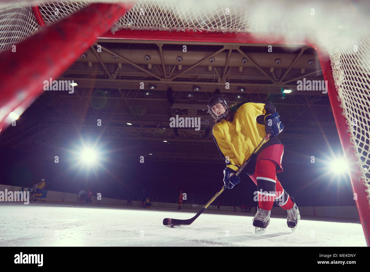 teen girl children ice hockey player in action kicking puck with stick