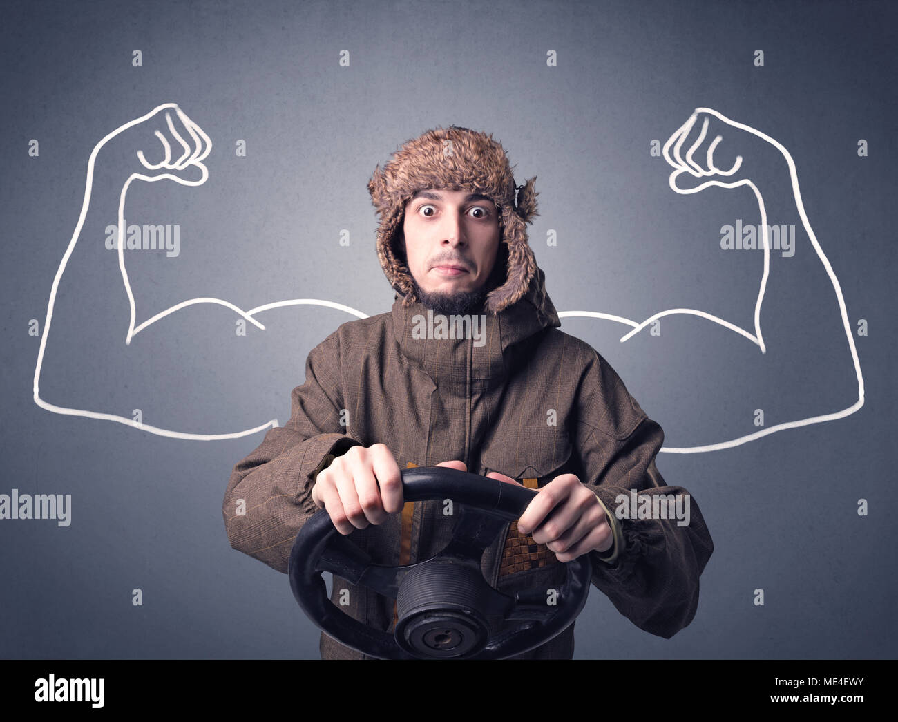 Young man holding black steering wheel with muscly arms drawn next to
