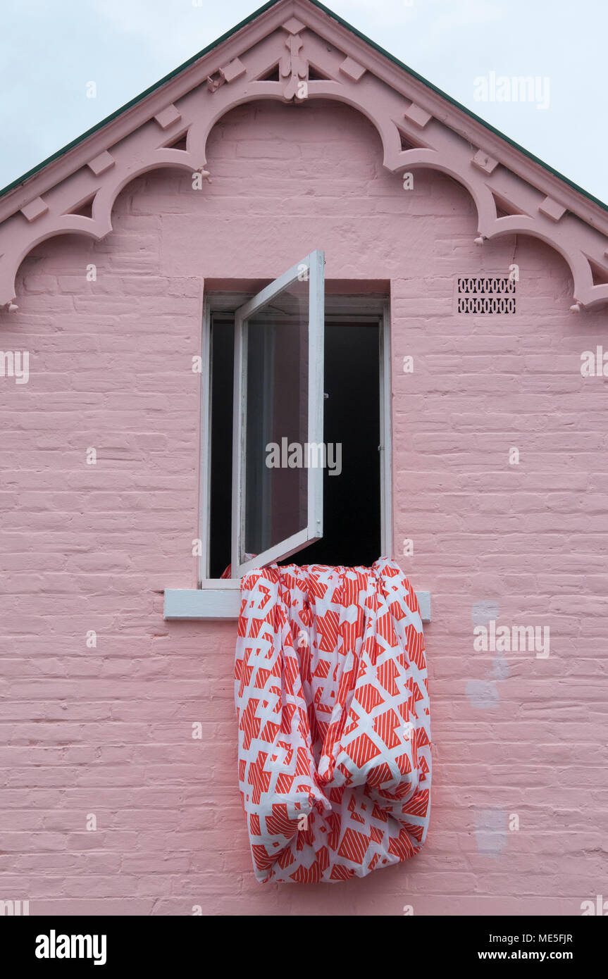 Bedding hung out to dry from the attic window of a Victorian Gothic style house in Battery Point, Hobart, Tasmania, Australia Stock Photo