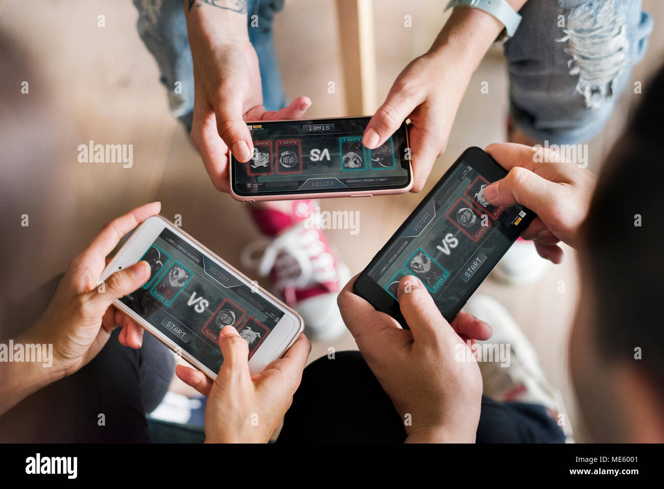 Group of diverse friends playing game on mobile phone Stock Photo