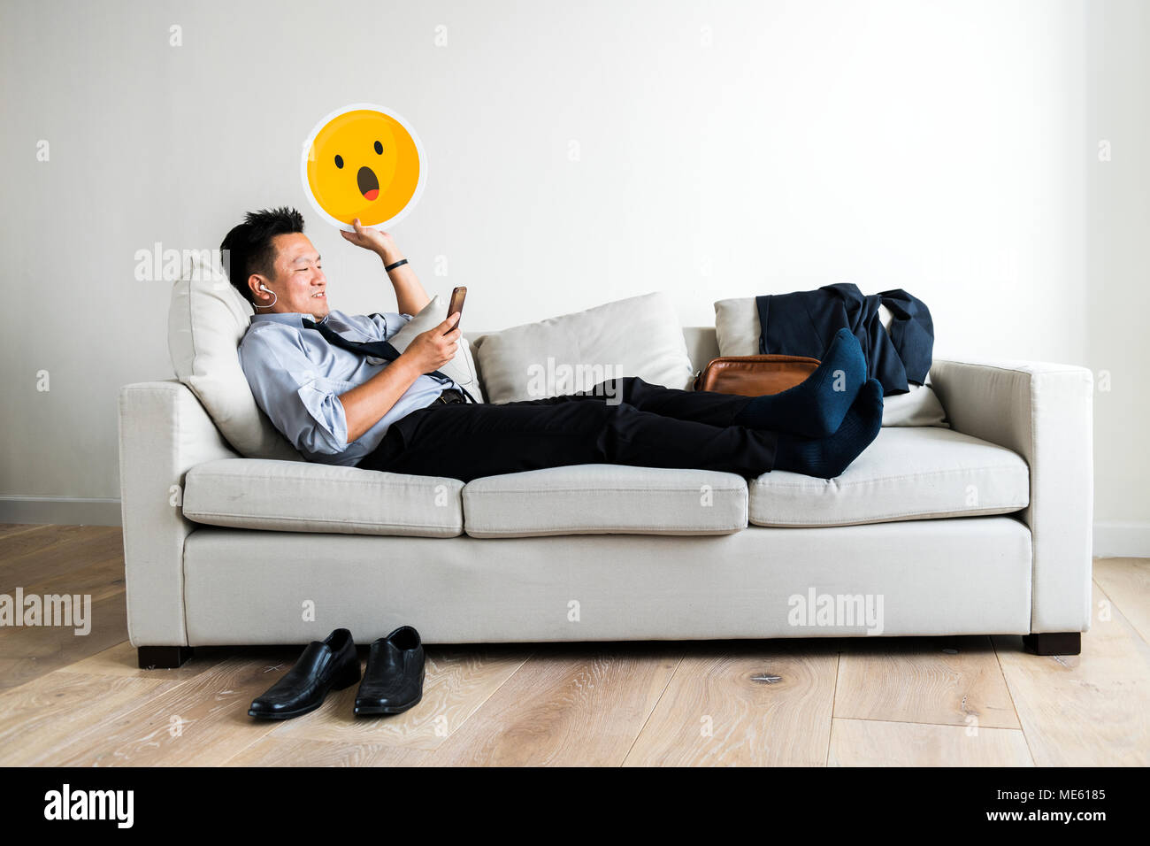 Asian businessman taking break laying on couch Stock Photo Alamy