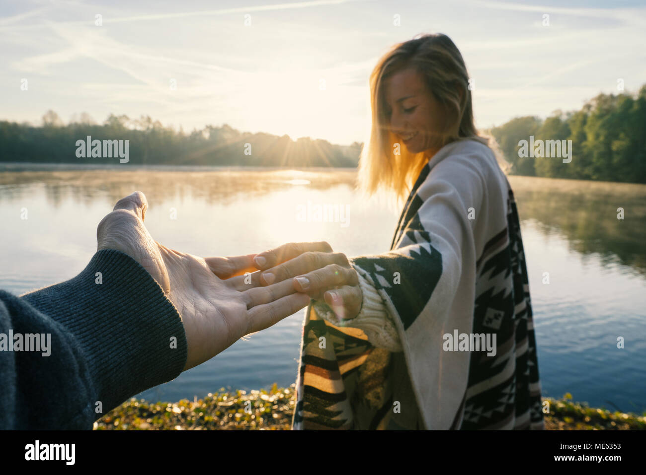 Follow me to concept, Young woman leading boyfriend to the lakeshore at  sunrise, holding hands, People travel couple beginning. Shot in France,  Europe Stock Photo - Alamy