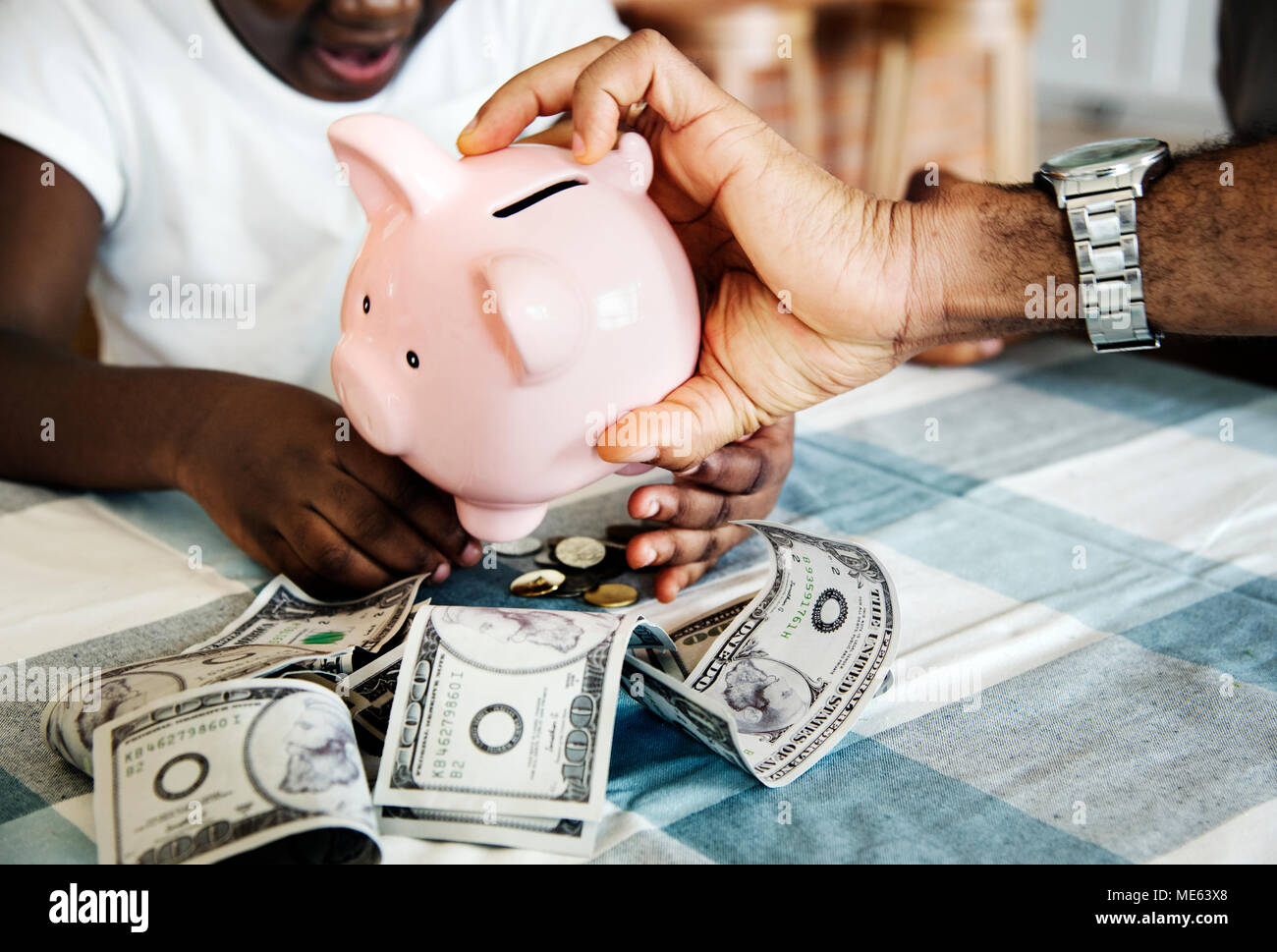 Dad and daughter saving money to piggy bank Stock Photo - Alamy