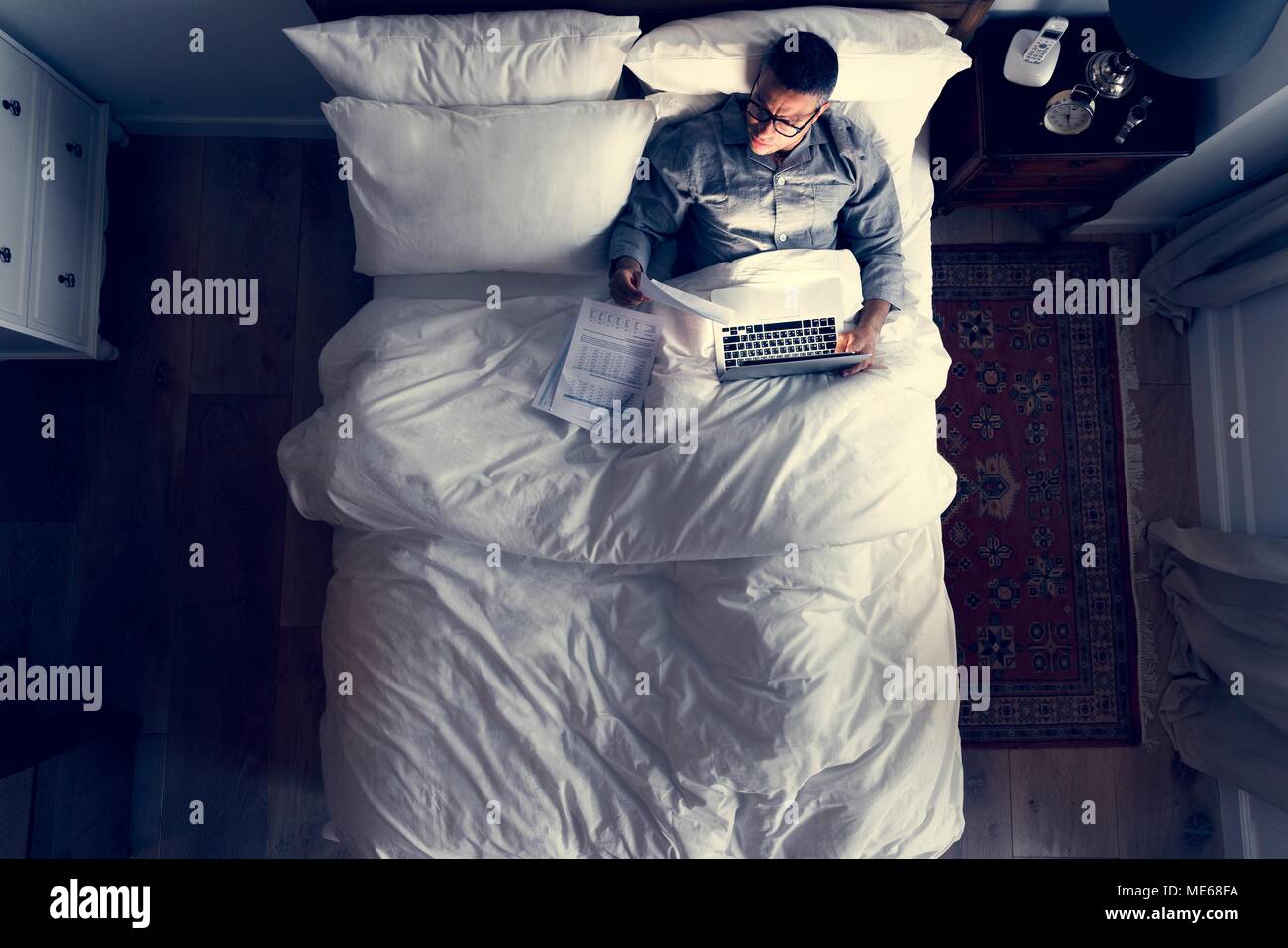 Business man on bed working at night Stock Photo