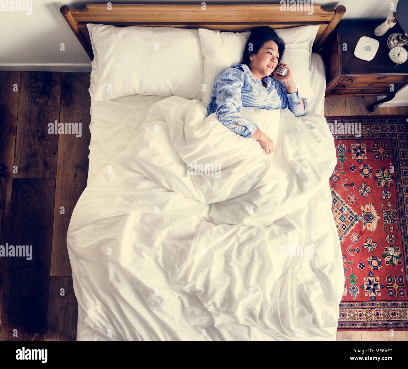 Woman in bed talking on the phone Stock Photo