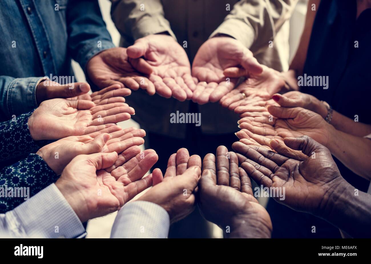 Group of diverse hands palms circle support together teamwork aerial view Stock Photo