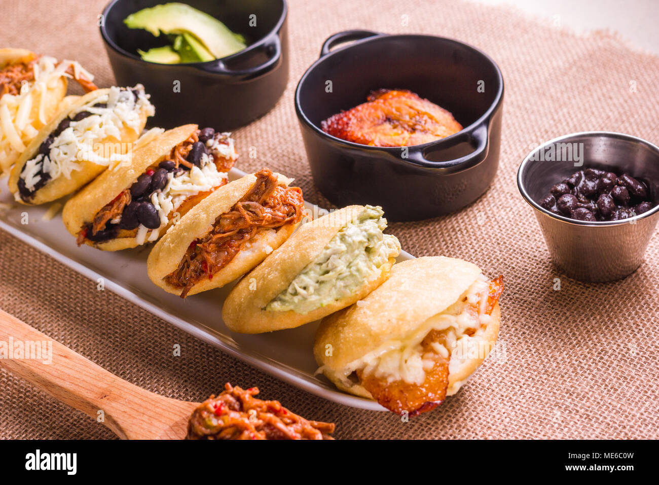 Different types of arepas, meat, black beans, cheese, fried plantain