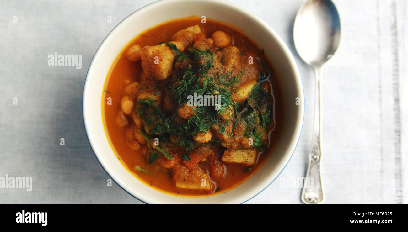 Simple vegetable soup. European cuisine. Chickpeas, potato and carrot. Organic food. Vegan dish. Vegetarian lunch. Top view. Wide photo. Stock Photo