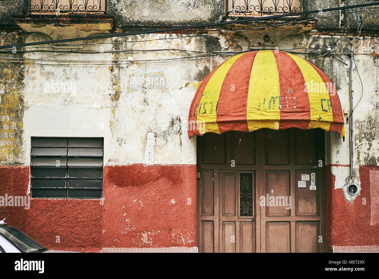 The Vintage Awning In Red And Yellow Mounted On The Front Door Of