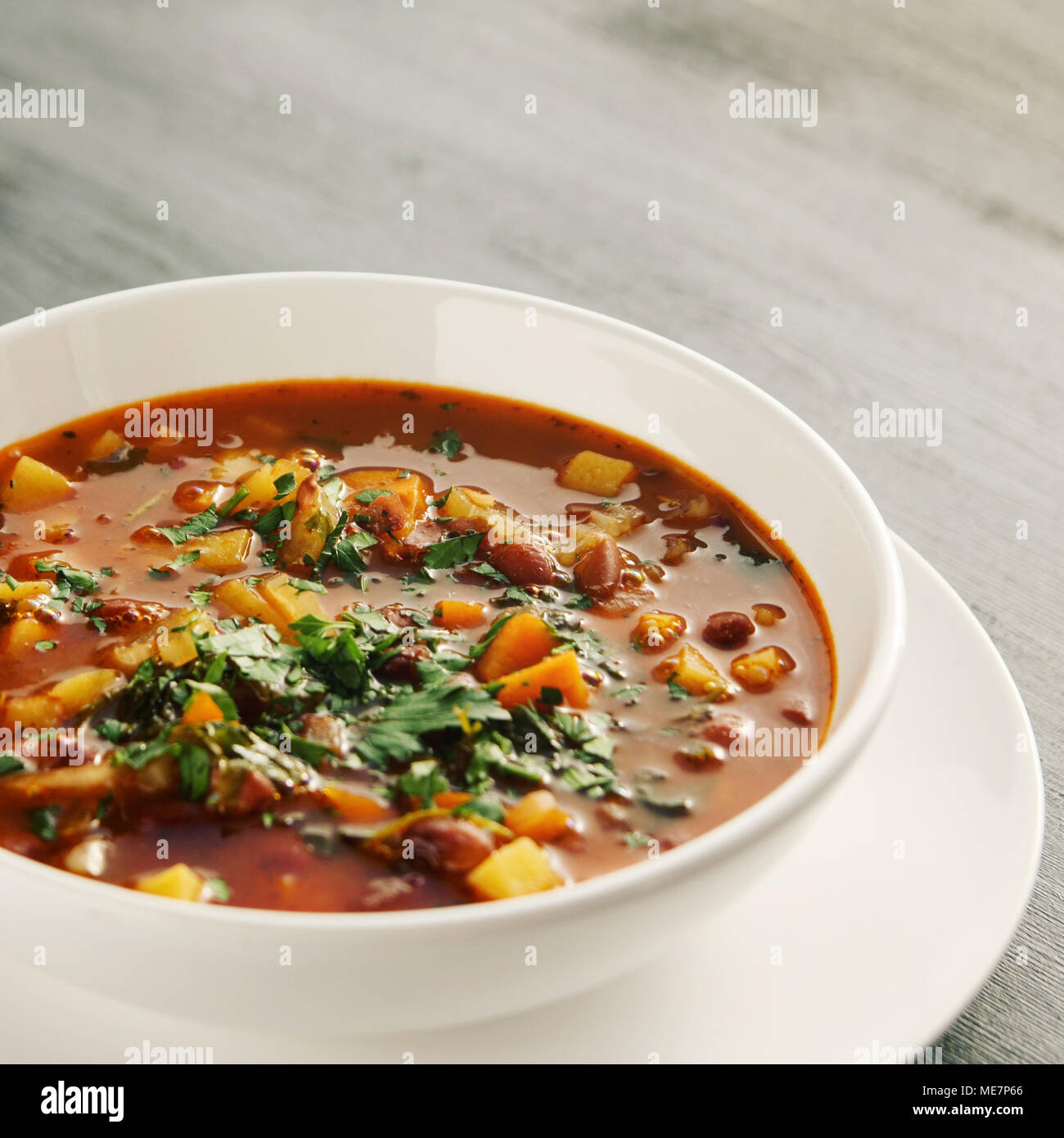 Tomato soup with red beans, potato and carrot. Vegan diet. European cuisine. Vegetarian dish. Main course. Organic meal. Toned photo. Stock Photo
