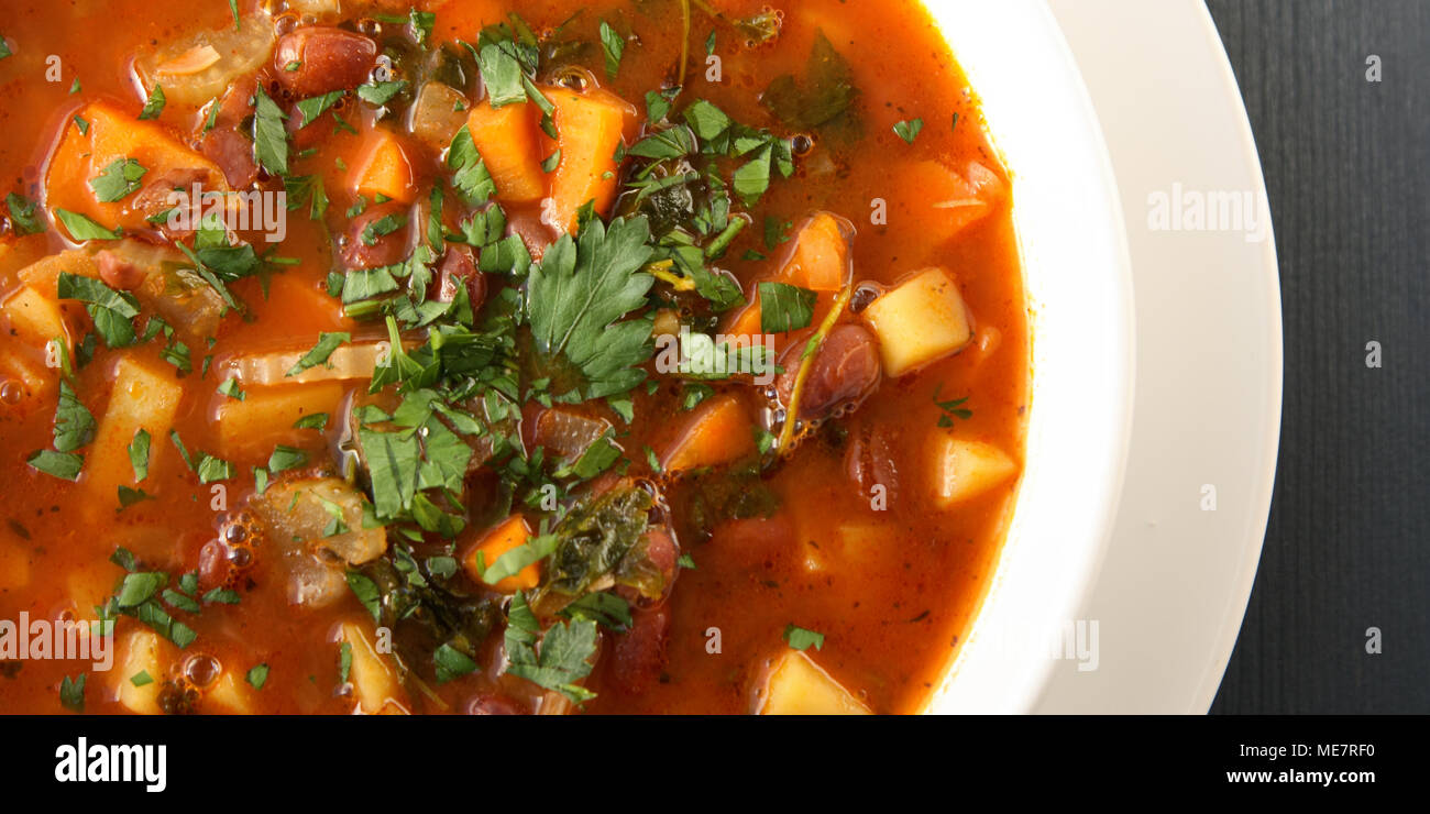 Tomato soup with red beans, potato and carrot. Vegan. European cuisine. Top view. Vegetarian dish. Main course. Wide photo. Stock Photo