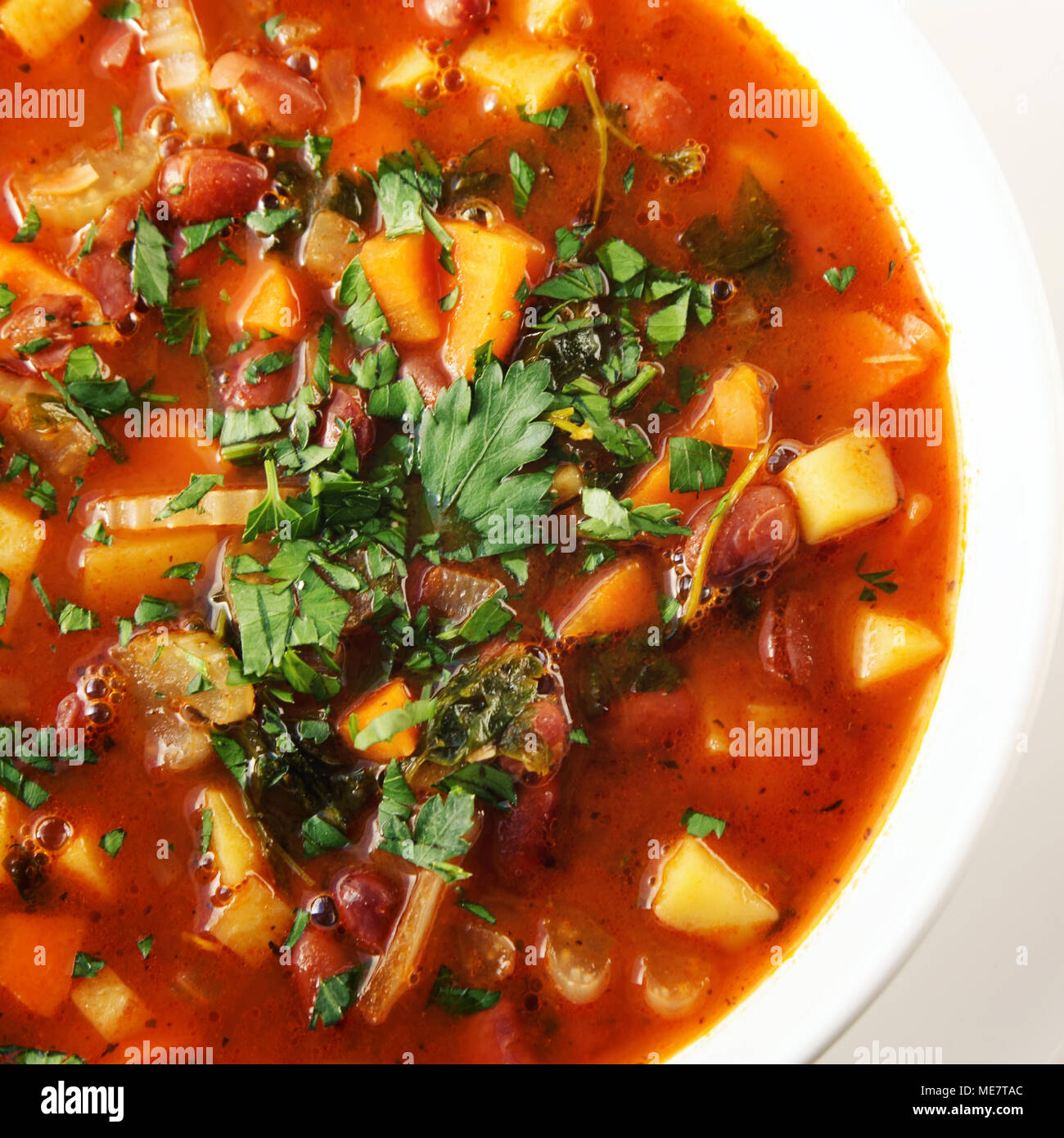 Tomato soup with red beans, potato and carrot. Vegan. European cuisine. Top view. Vegetarian dish. Main course. Colorful photo. Close up. Meatless dis Stock Photo