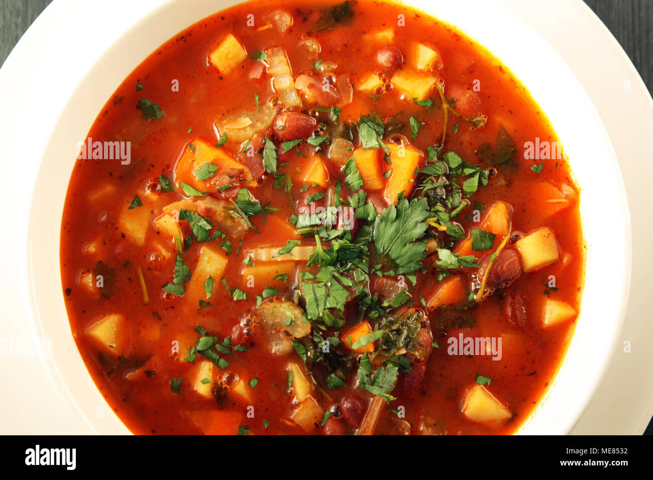 Tomato soup with red beans, potato and carrot. Vegan. European cuisine. Top view. Vegetarian dish. Main course. Colorful photo. Stock Photo