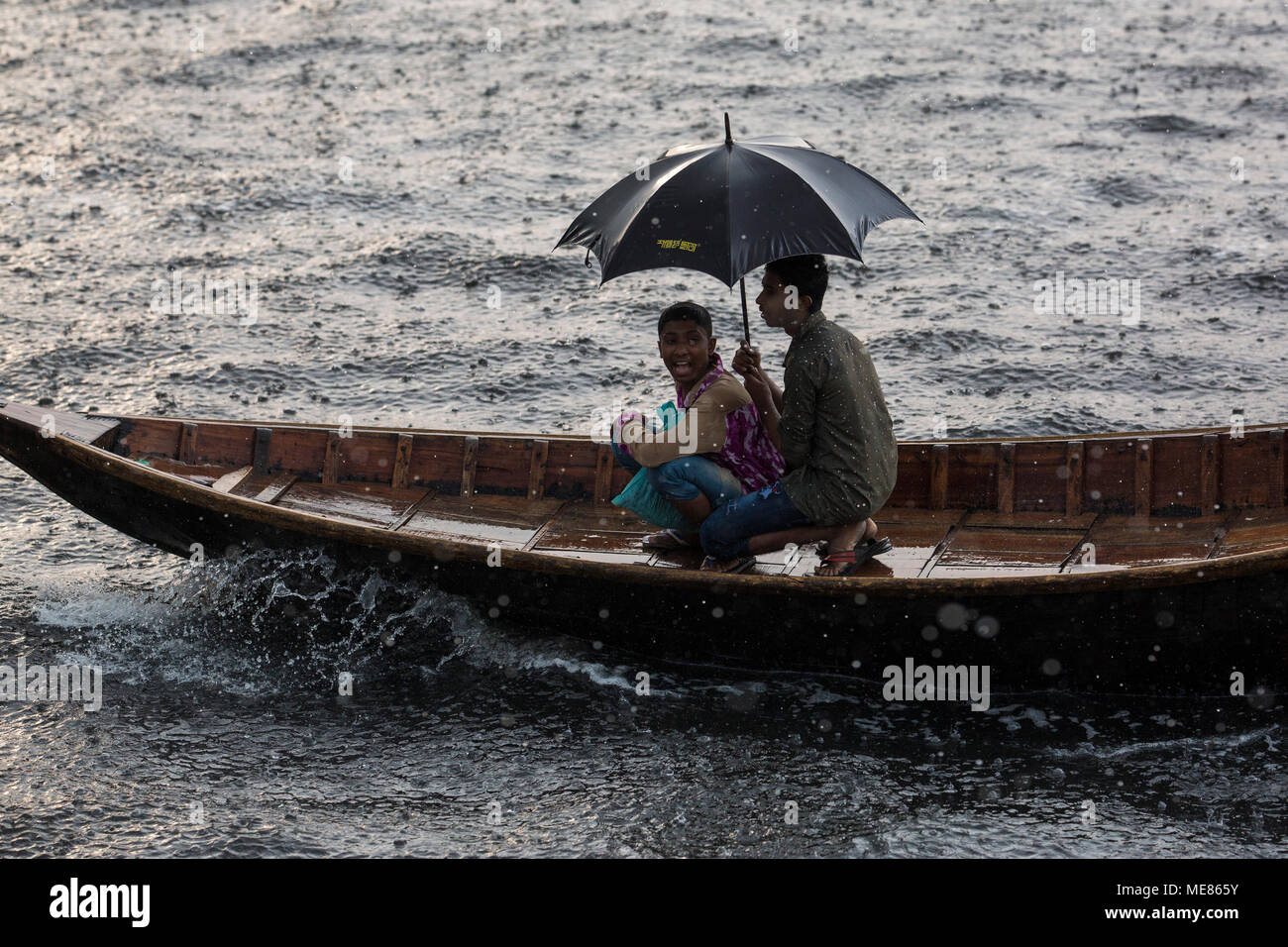 Dhaka, Bangladesh. 21st April, 2018.  Bangladeshi commuters use boats to cross the Buriganga River  during rain in Dhaka, Bangladesh on April 21, 2018.  The Buriganga River is economically very important to Dhaka, used to transport a multitude of goods, produce and people everyday. It is estimated that some fifty thousand people cross the Buriganga River from Keraniganj to Dhaka, for work everyday. Credit: zakir hossain chowdhury zakir/Alamy Live News Stock Photo