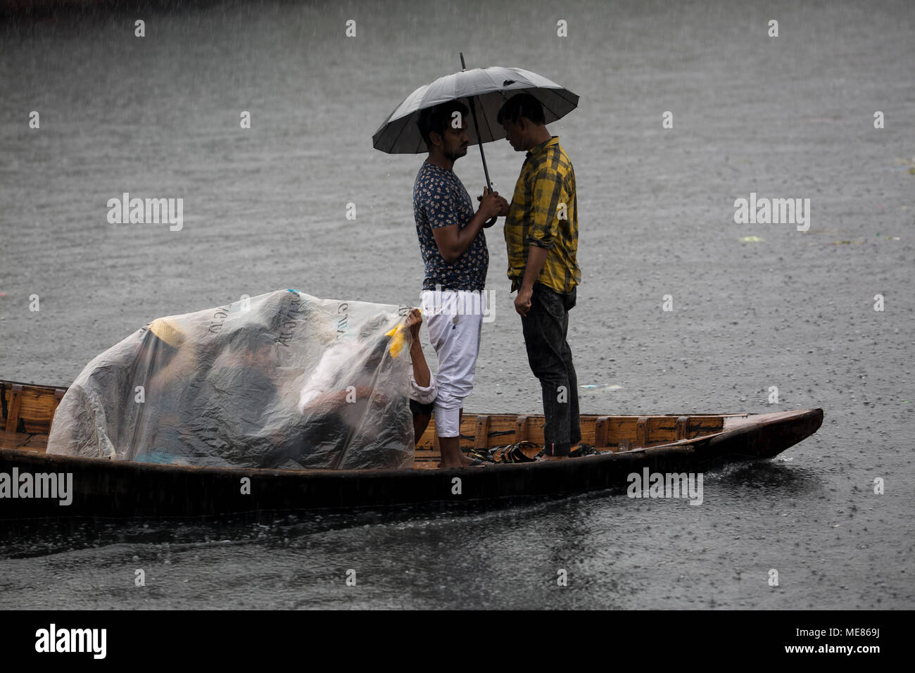 Dhaka, Bangladesh. 21st April, 2018.  Bangladeshi commuters use boats to cross the Buriganga River  during rain in Dhaka, Bangladesh on April 21, 2018.  The Buriganga River is economically very important to Dhaka, used to transport a multitude of goods, produce and people everyday. It is estimated that some fifty thousand people cross the Buriganga River from Keraniganj to Dhaka, for work everyday. Credit: zakir hossain chowdhury zakir/Alamy Live News Stock Photo