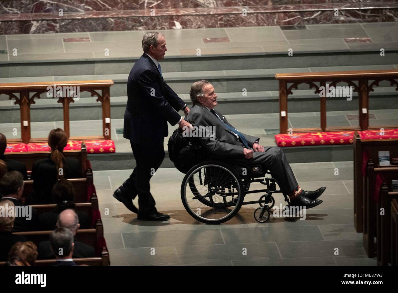 Former president W. Bush pushes wheelchair of his father, former