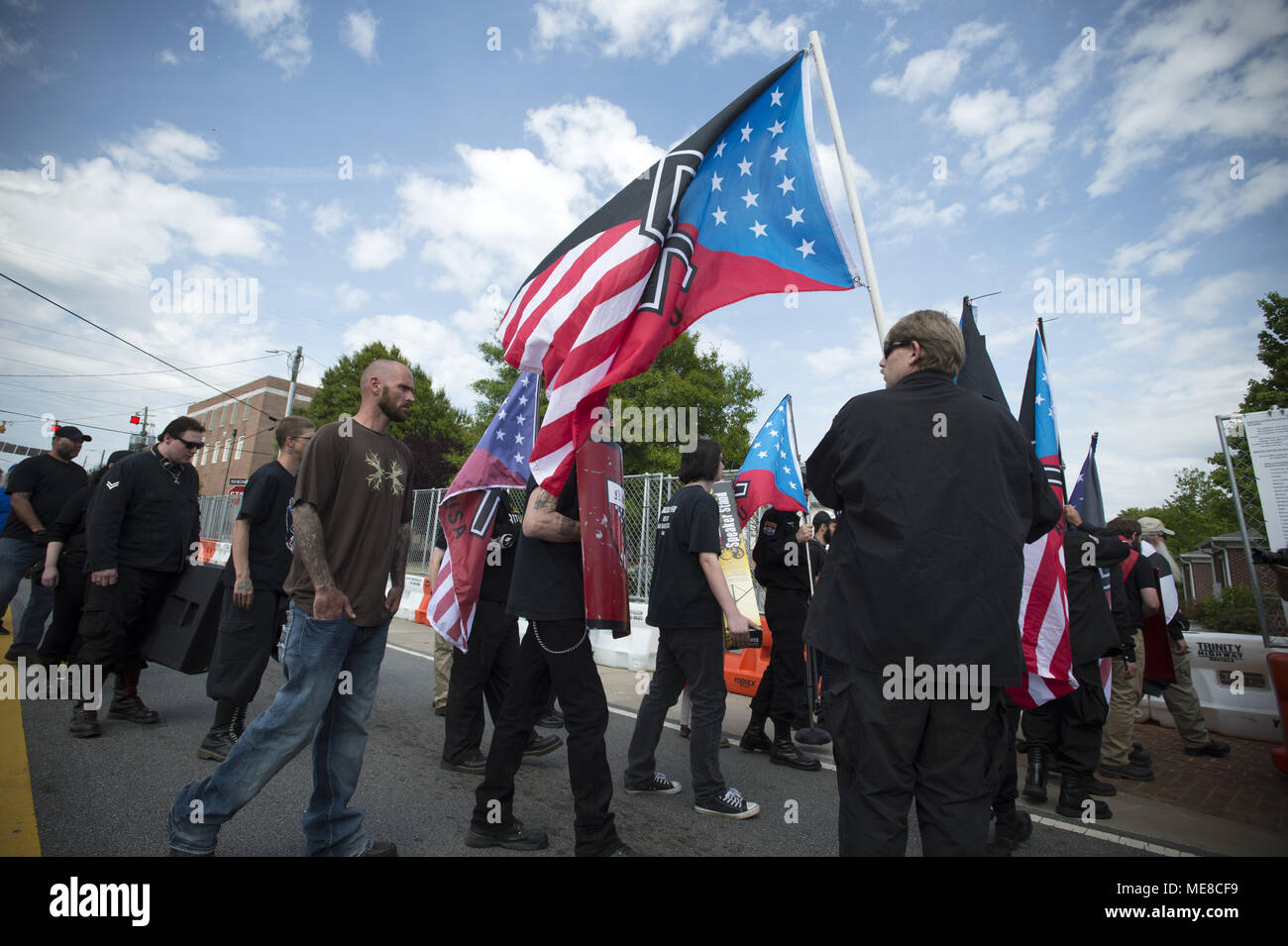 Newnan, GA, USA. 21st Apr, 2018. An estimated 35 Neo Nazi white supremacists gather to rally in park in this small Georgia town, surround by by hundreds of law enforcement personnel and hundreds of anti-white supremacist protesters. A number of County residents were angered by the high costs for what they was excessive police presence. Pictured: Neo-Nazi group makes its way to rally, under heavy police protection Credit: Robin Rayne Nelson/ZUMA Wire/Alamy Live News Stock Photo