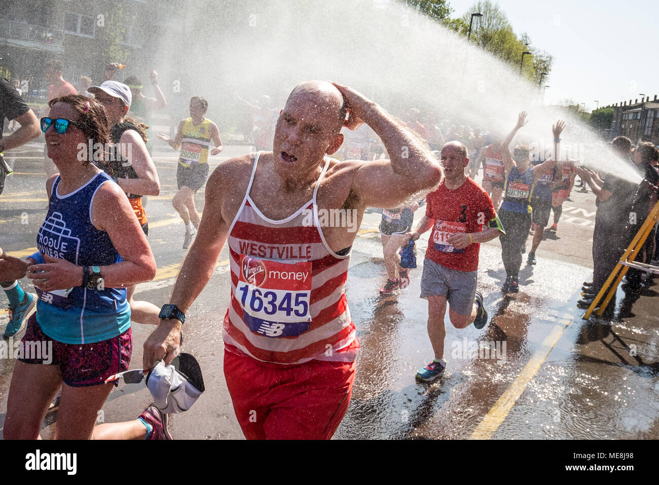 London, UK. 22nd April, 2018. Deptford fire station provides much needed water cooling using their fire hoses as runners of the 38th London Marathon passes through Deptford on one of the hottest marathons on record. Temperatures are expected to peak at 23C (73.4F). Credit: Guy Corbishley/Alamy Live News Stock Photo