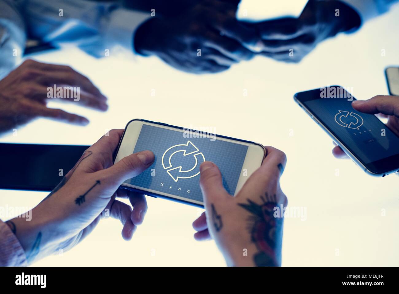 Hands holding smartphone with sync symbol on a screen Stock Photo
