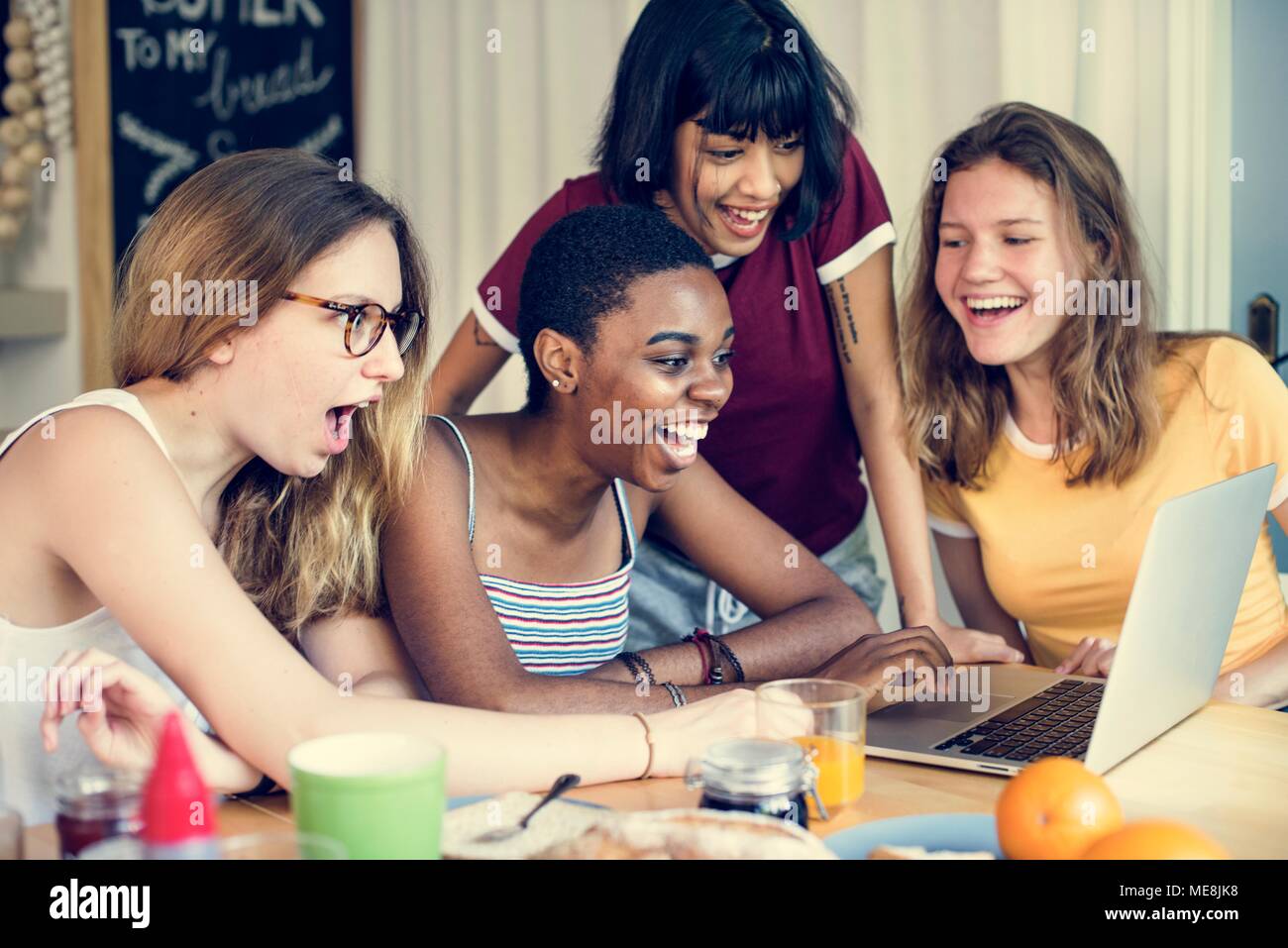 Group of diverse friends looking at computer laptop with surprise face expression Stock Photo