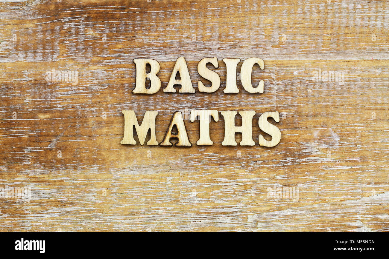 Basic maths written with wooden letters on rustic surface Stock Photo
