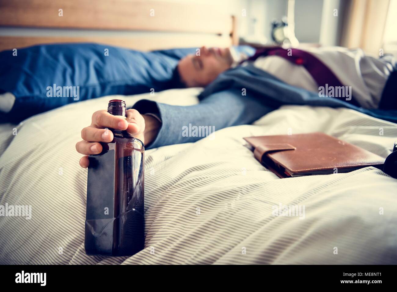 A drunk man passing out in bed Stock Photo