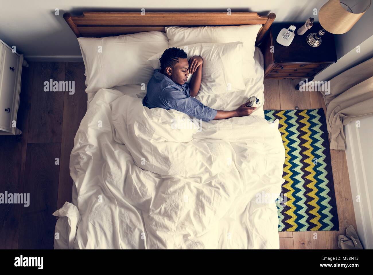 Man waking up in the morning by an alarm clock Stock Photo