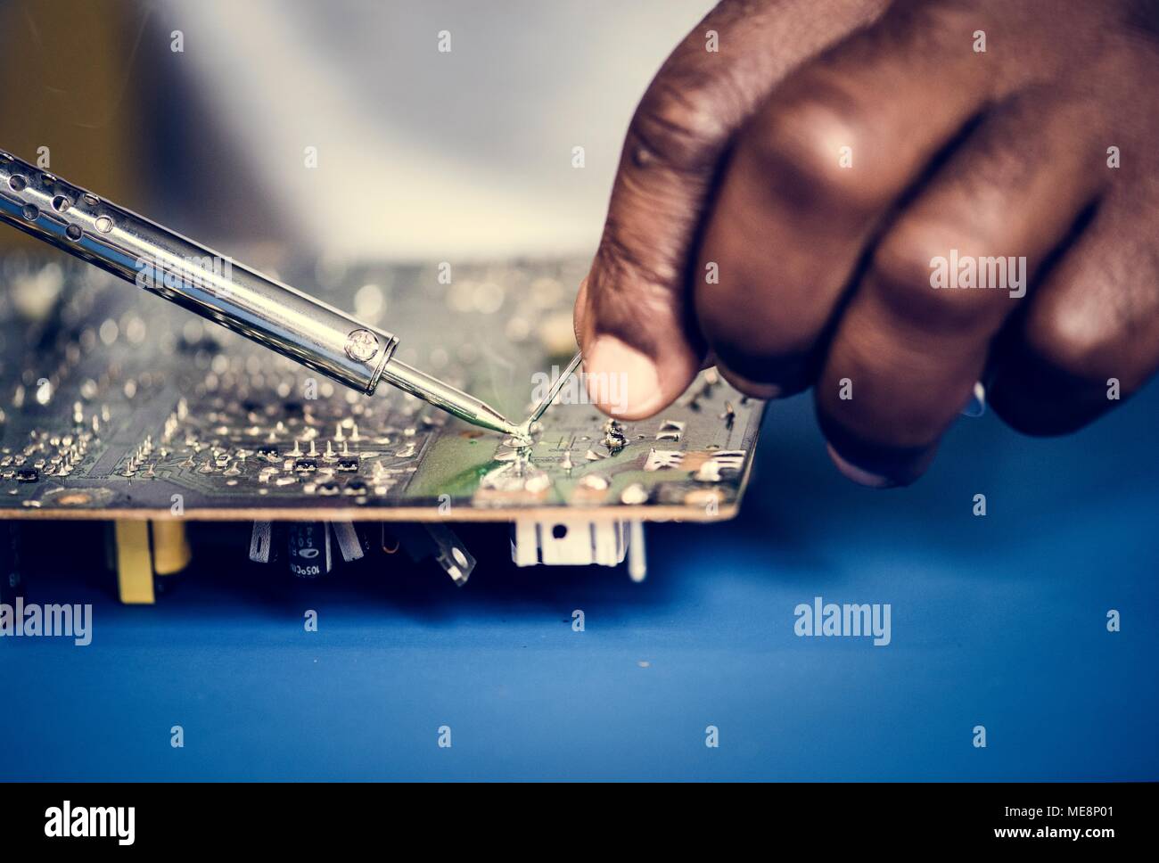 Closeup of tin soldering with electronics circuit board Stock Photo