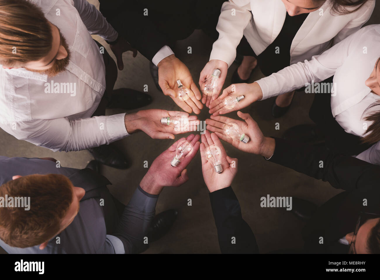 Teamwork and brainstorming concept with businessmen that share an idea with a lamp. Concept of startup Stock Photo