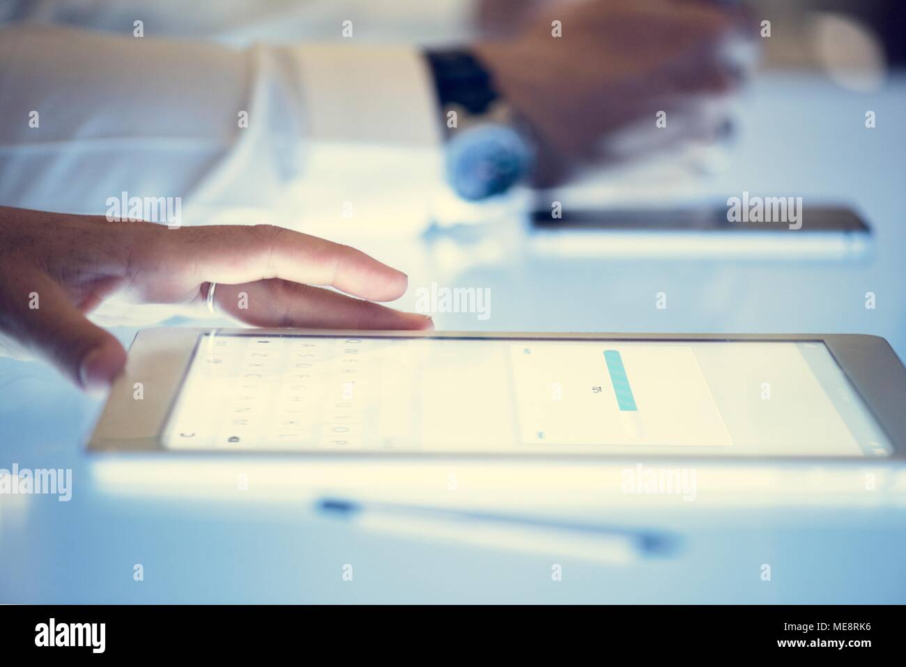 Hand on a digital tablet with downloading on a screen Stock Photo