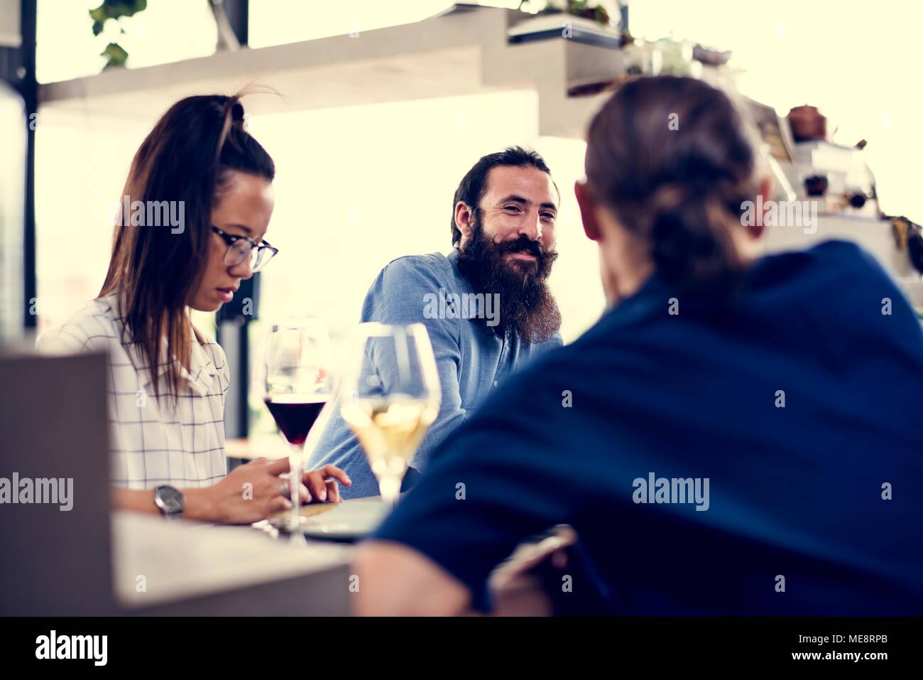 People having wine and talking with friends Stock Photo