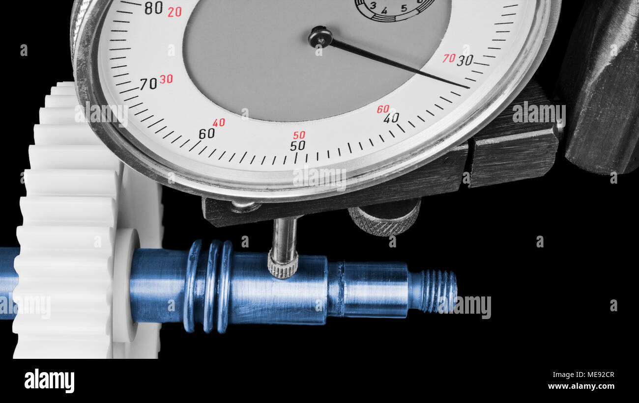 Dial gauge when measuring shaft with cogwheel. Closeup of measurement